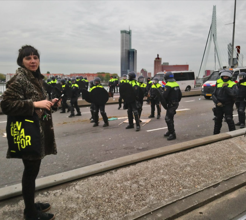 Een persoon tijdens de woonprotesten in Rotterdam met een Generator tas.